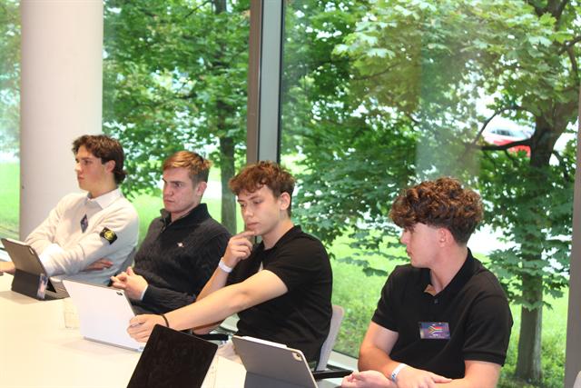 Delegates in session by the window.